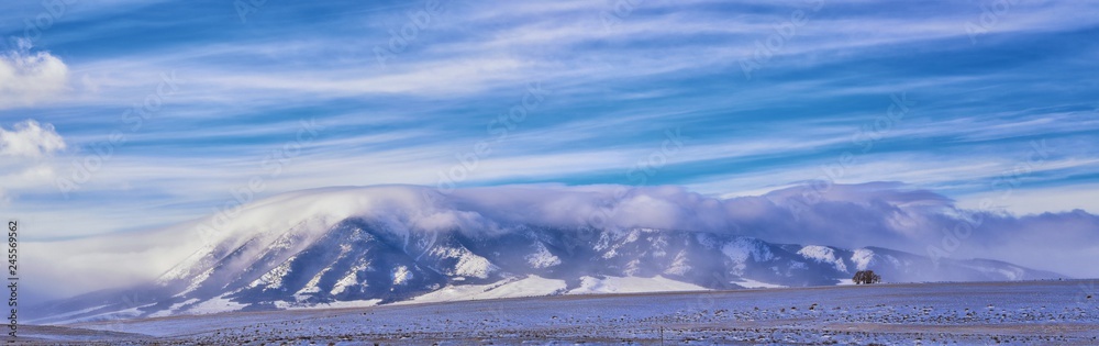Wyoming countryside panoramic views during a blizzard with mountain with snow covered with overcast grey cloudy sky. Wyoming, United States.
