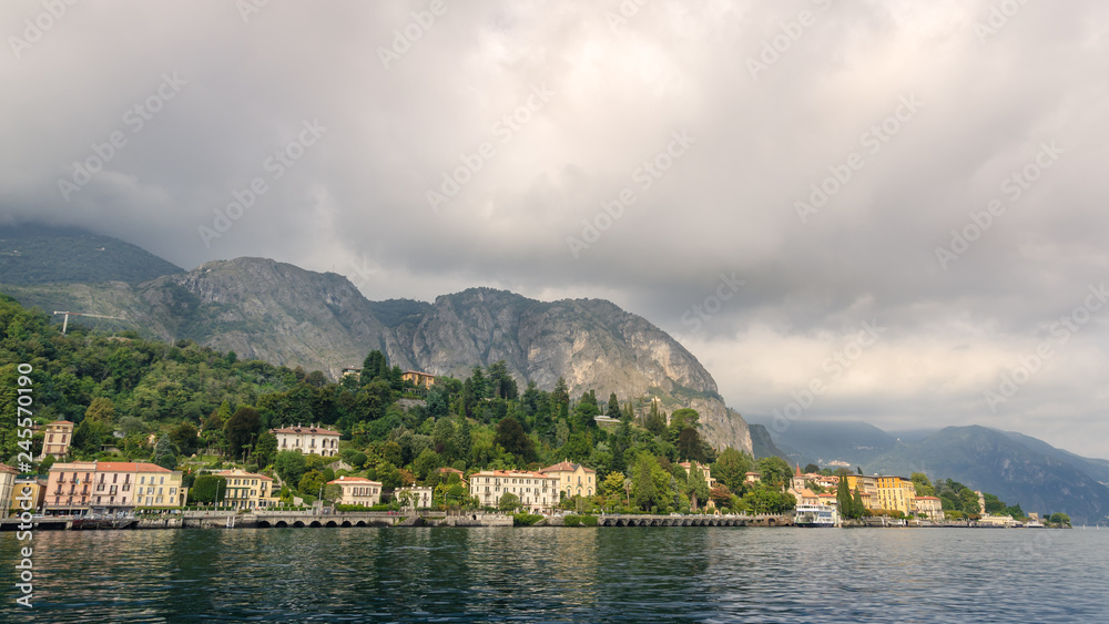 View of village in forest in Lake Como from ferry at sunset, Lake Como, Italy