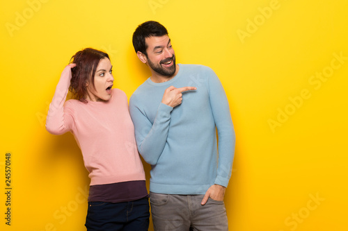 Couple in valentine day pointing finger to the side with a surprised face © luismolinero