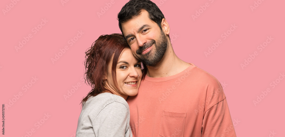Couple in valentine day hugging over isolated pink background Couple in valentine day hugging over isolated pink background