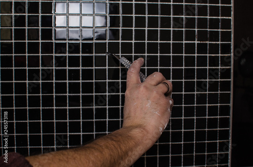 laying a tile black mosaic hands master