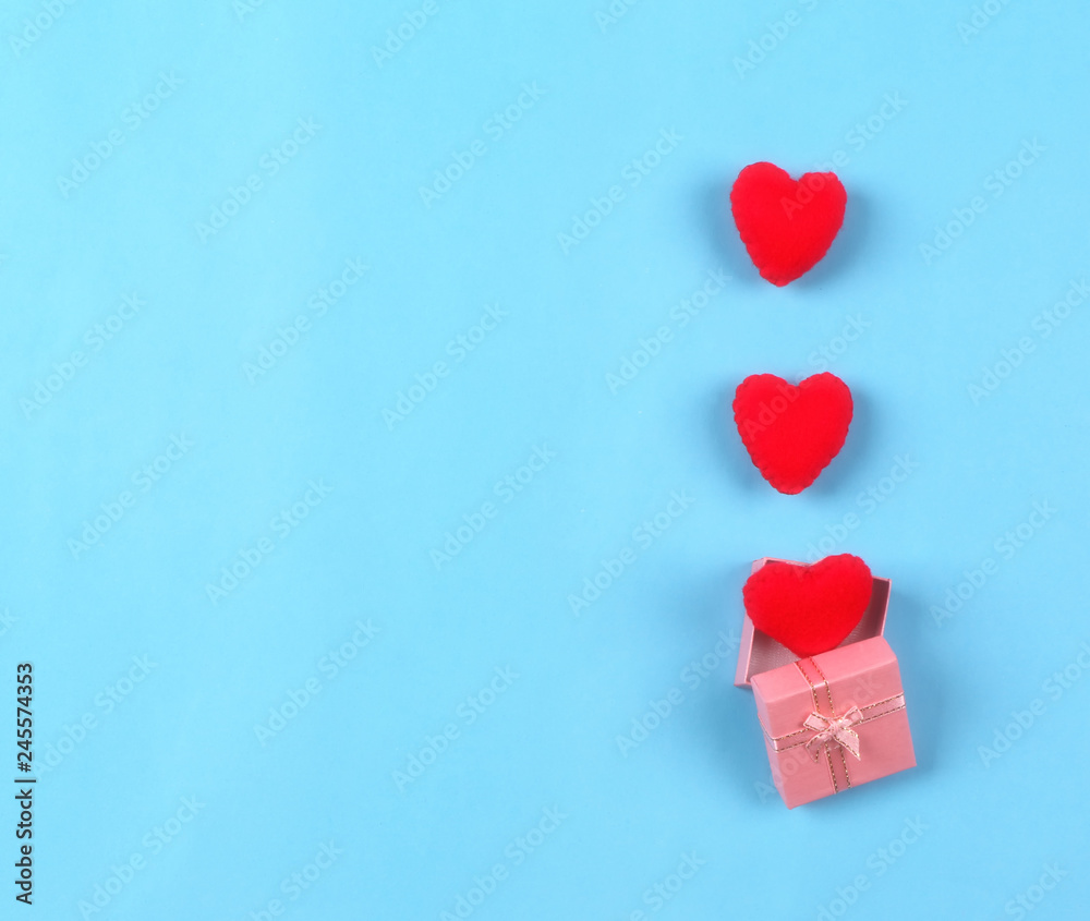 beautiful red hearts in gift box on pastel blue background. Valentines day concept flat lay beautiful red hearts in gift box on pastel blue background. Valentines day concept flat lay