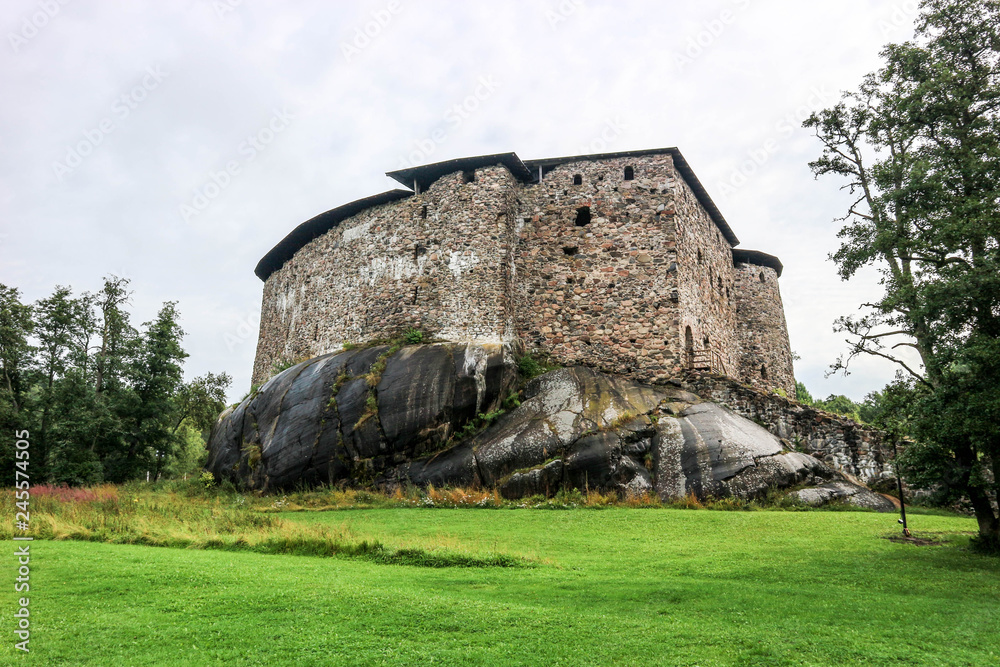 Medieval Raseborg castle on the rock with green grass below, Finland