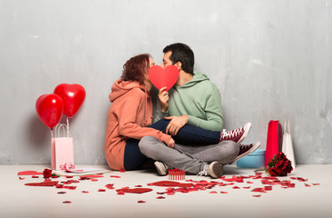 Couple in valentine day holding a heart symbol and kissing