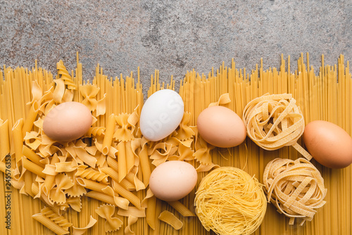 Different types of pasta that we use every day in the kitchen when cooking. View from above. Products flat-lying. Place for a description or text. A product made of flour and eggs.