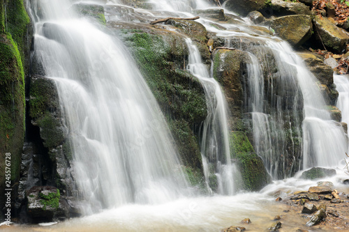 bottom of the beautiful waterfall among the forest. wonderful nature scenery in spring or summer. huge mossy boulders. refreshing stream