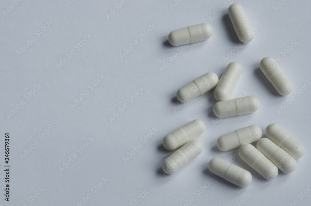 Medical and pharmacy theme. White pills on white background. Medical and pharmacy theme. White pills on white background.