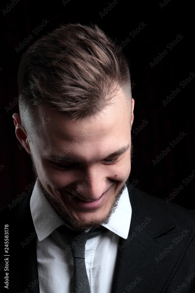 Close up portrait of elegant young fashion man in tuxedo laughing.on black background Close up portrait of elegant young fashion man in tuxedo laughing.on black background