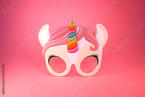 Unicorn sunglasses isolated on a pastel pink background. Minimal summer concept.