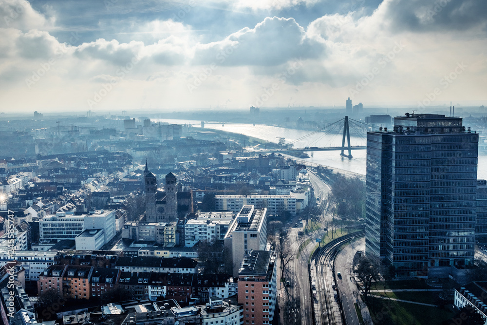 Aerial city panorama over the roof tops with office buildings and river Rhine view with dramatic clouds Köln, Cologne in Germany