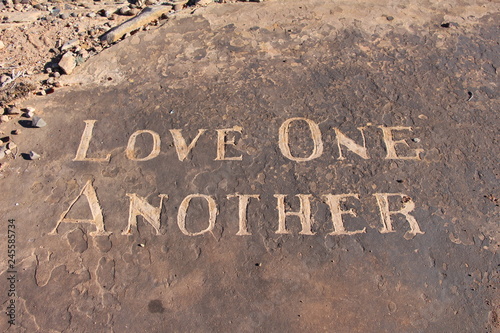 Love One Another carving in sandstone