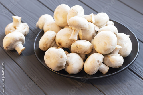 Closeup mushrooms champignon in a plate on the table