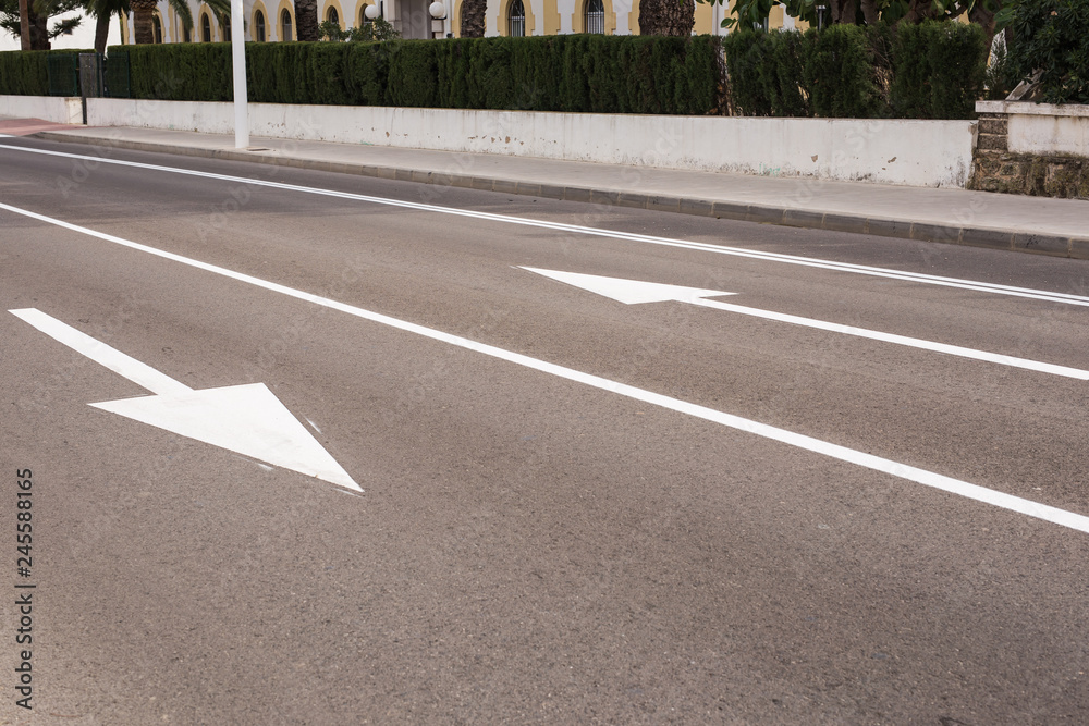 Arrow signs as road markings on a street with two lanes Arrow signs as road markings on a street with two lanes