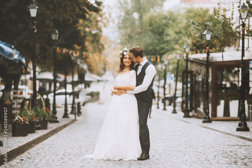 Naklejka premium Handsome loving couple newlyweds gently embrace, romantic wedding moment