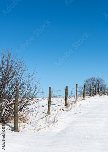 Outskirts of the village, Fence with barbed wire in the village, winter time, land in the snow