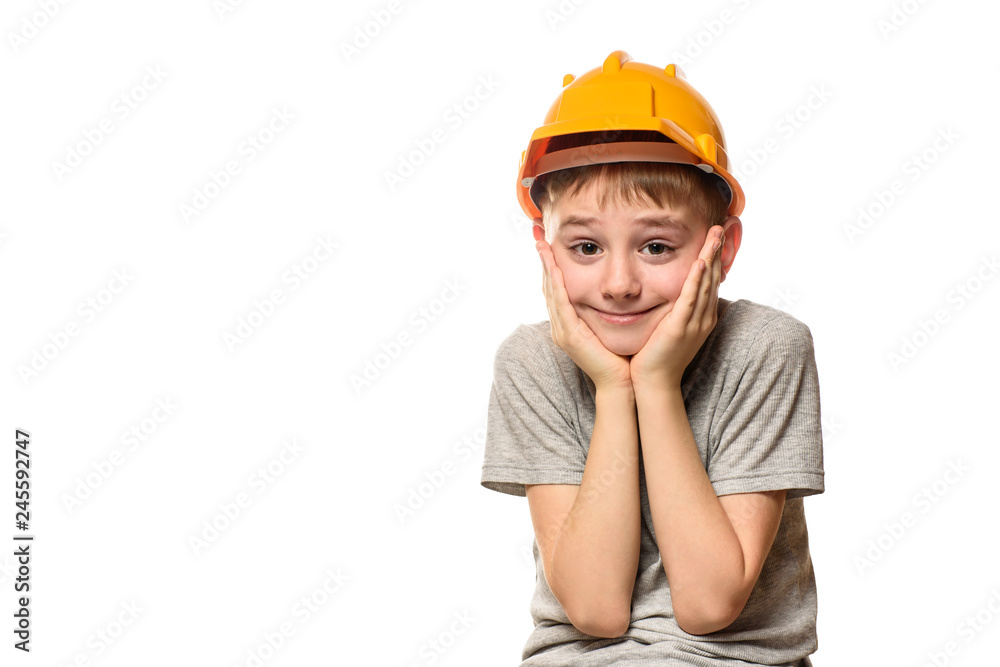 Boy in orange construction helmet put hands on cheek. Portrait. Isolate on white background Boy in orange construction helmet put hands on cheek. Portrait. Isolate on white background
