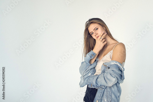 beautiful young female peeks though fingers, covers face with both hands, has frightened expression as notices something terrible or scarying, isolated over white background. - Image