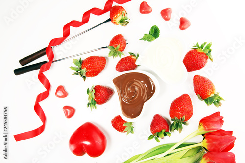 Valentine Chocolate fondue melted with fresh strawberries and dark and white chocolate. Tublips and sugar hearts. photo