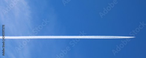 Engine exhaust white contrails forming behind an aircraft photo