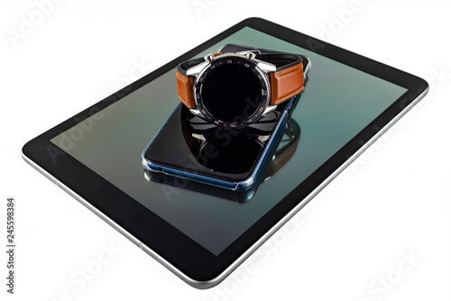 The smart watch lies on the smartphone, the smartphone lies on the tablet. White background, isolate.