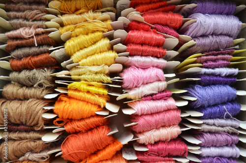 Set of colorful threads in a warm colors for embroidery and sewing, top view