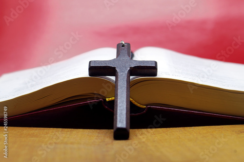Black wooden cross  on bible book.