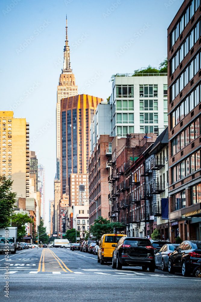 34nd street, Manhattan viewed from Hudson River pedestrian zone with Empire State Building in background in New York City during sunny summer daytime at sunset
