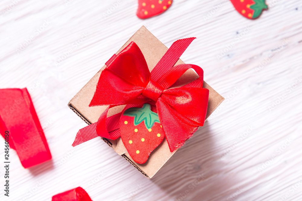 Obraz premium Gift wrapped cardboard box on wooden background