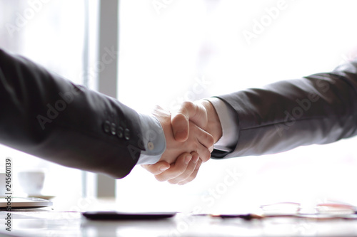 close up.a confident handshake of business partners at the desktop