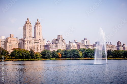 View of Manhattan skyline viewed from Jacqueline Kennedy Onassis Reservoir in Central Park in New York City during sunny summer day