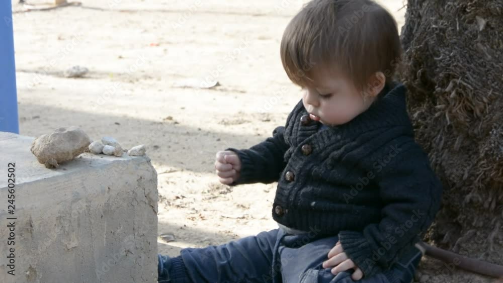 Little cute boy playing with stones Little cute boy playing with stones