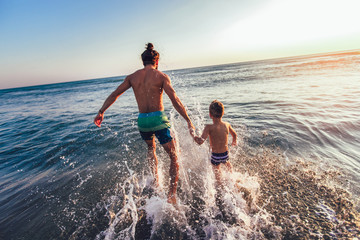 Father and son playing on the beach at the day time