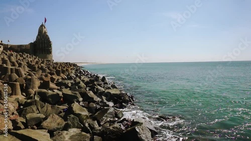 Panning shot of breakwater, lighthouse, temples near dwarka beach Gujarat india photo