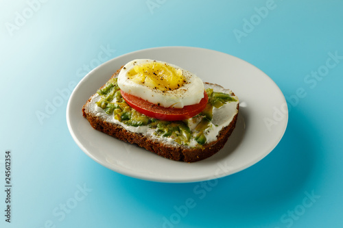 sandwich with avocado salad on white plate blue background Avocado and mayonnaise with egg and paprika.