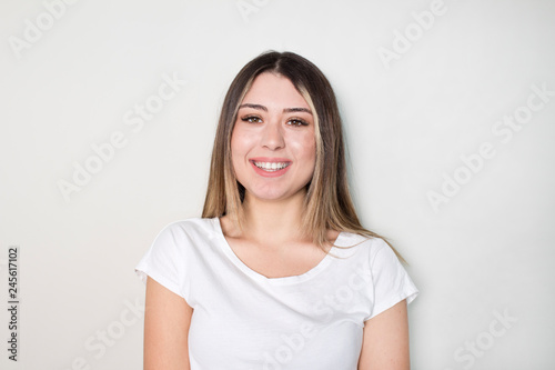 Portrait of young beautiful cute cheerful girl smiling looking at camera over white background.