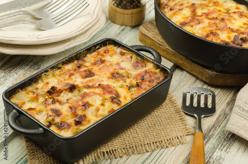 Potato gratin with parmesan cheese, cream and cured bacon from South Tyrol. Tartiflette: baked potatoes with bacon and cheese close up. Scalloped potato casserole 