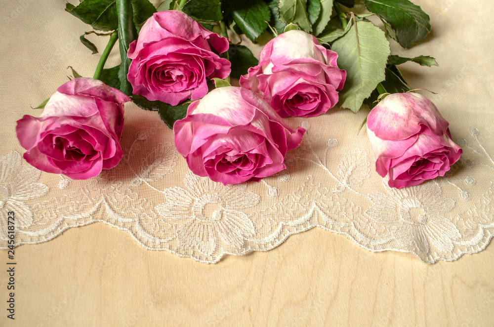 A bouquet of large magnificent roses with petals, painted white with pink around the edge, lying on top of embroidered openwork fabric
A bouquet of large magnificent roses with petals, painted white with pink around the edge, lying on top of embroidered openwork fabric
