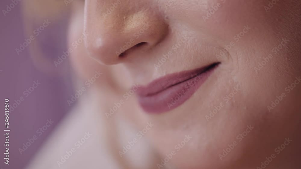 Beautiful and lovely bride. Pretty and well-groomed woman. Close up shot of bride's smile. Lips in lipstick. Wedding morning. Slow motion
