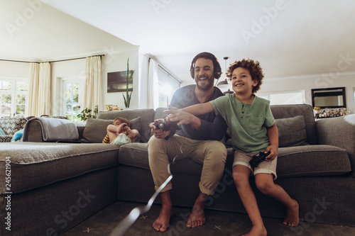 Father and son having fun at home playing video game