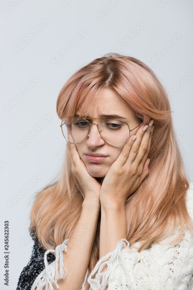 Studio portrait of frustrated girl in white sweater with stylish eyewear/female is afraid of making the wrong choice, thinking how solve situation/human emotions, facial expression concept.