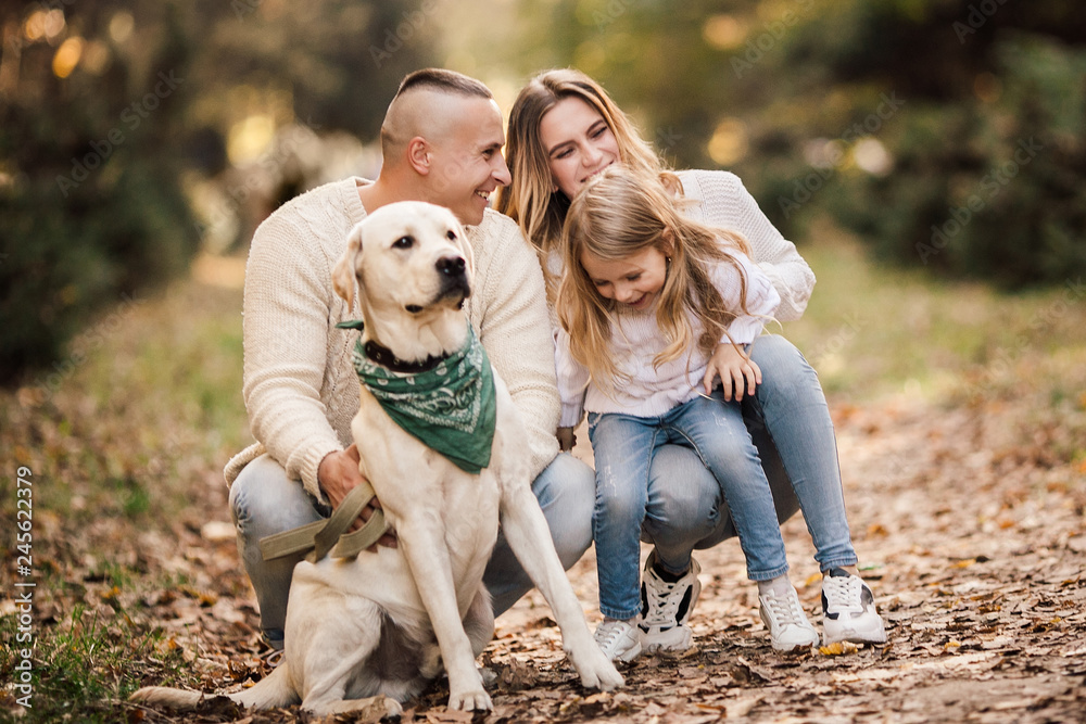 Happy beautiful family with dog labrador is having fun together walking the in park. Happy beautiful family with dog labrador is having fun together walking the in park.