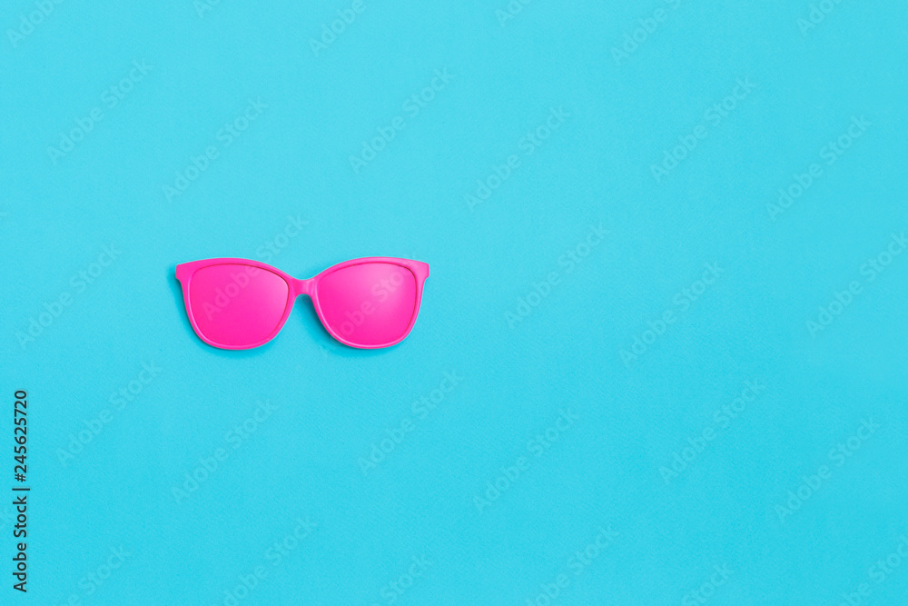 Pink glasses on blue background. Minimal concept. Creative concept. Hot Summer. Pop Art. Bright Sweet fashion Style.