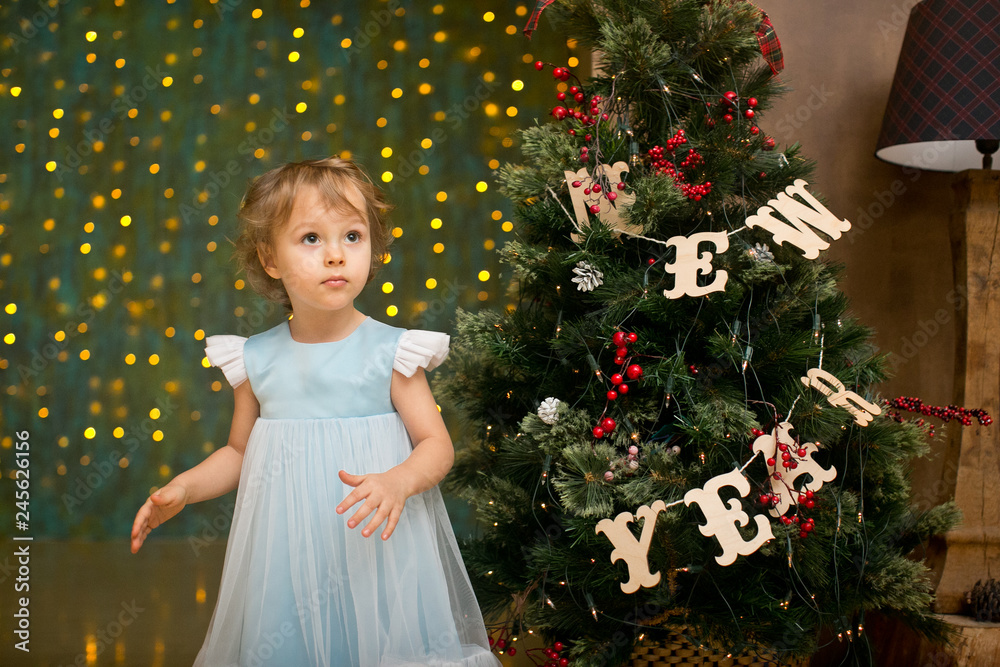 little girl under the christmas tree with christmas gifts