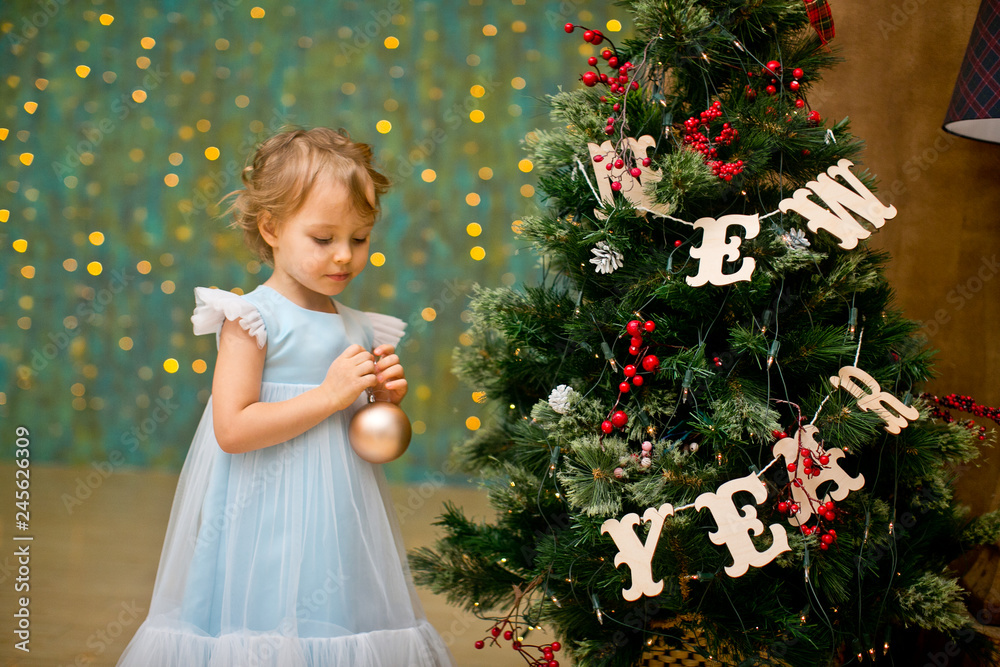 little girl under the christmas tree with christmas gifts