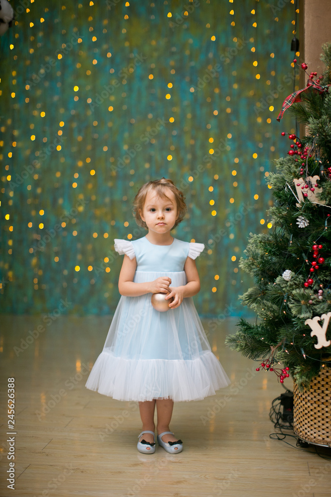 little girl under the christmas tree with christmas gifts