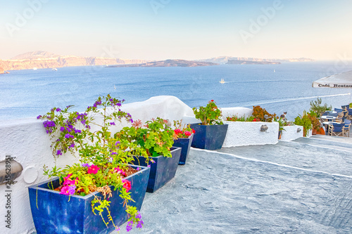 Travel Destinations.Picturesque Cityscape of Oia Village in Santorini with Volcanic Caldera and sailing Boats on Background.