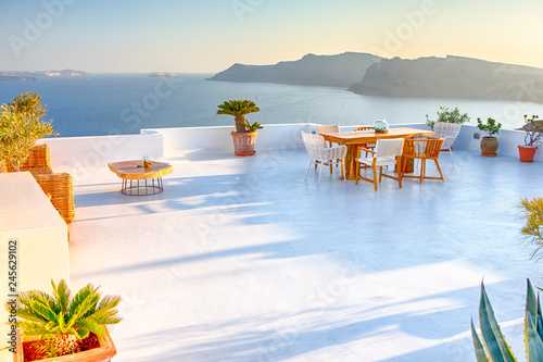 Tranquil Atmosphere at Open Air Terrace Restaurant in Beautiful Oia Village on Santorini Island in Greece in Front of Volcanic Caldera Mountain.