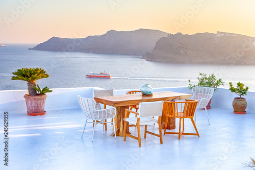 Intimate Romantic Places. Open Air Terrace Restaurant in Beautiful Oia Village on Santorini Island in Greece in Front of Volcanic Caldera Mountain.