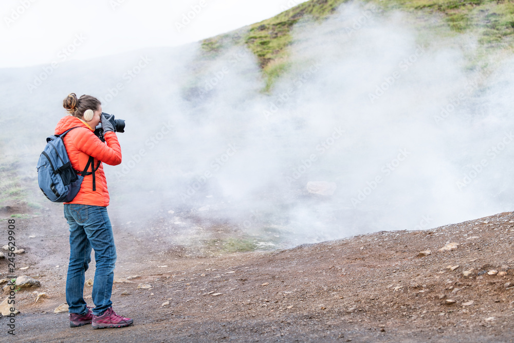 Reykjadalur, Iceland Hot Springs road footpath with steam fumarole vent during autumn day in golden circle with people woman girl taking picture photographing on hiking trail