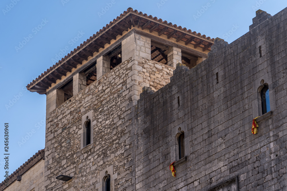 View of medieval buildings, tower and street in Girona Catalonia, Spain with blue sky, popular tourist town one hour from Barcelona